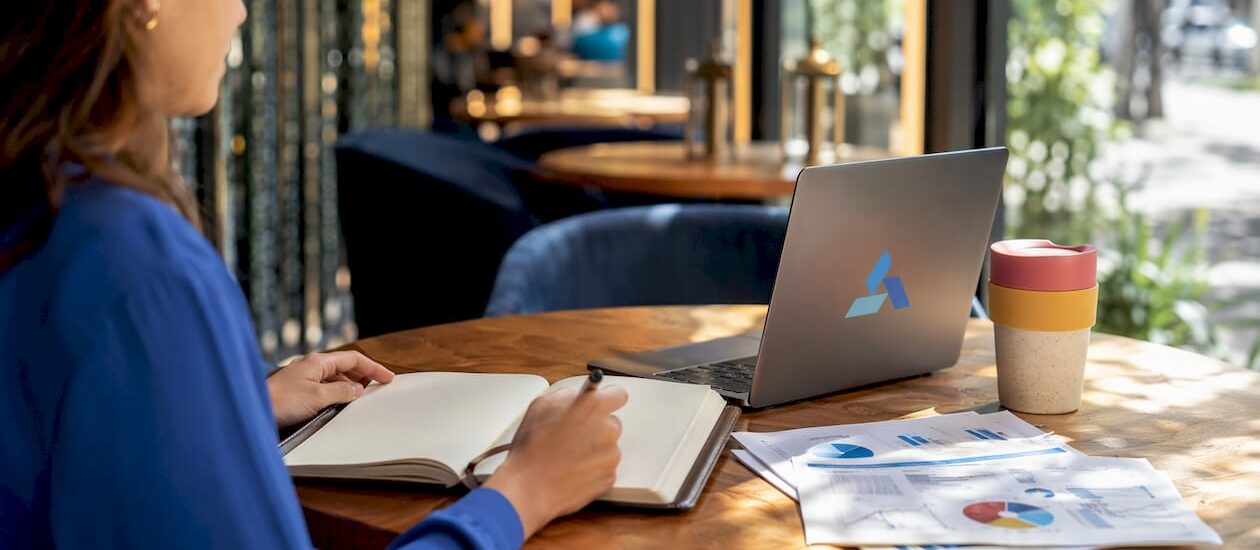 Workspace with notebook and Blue Prysm logo