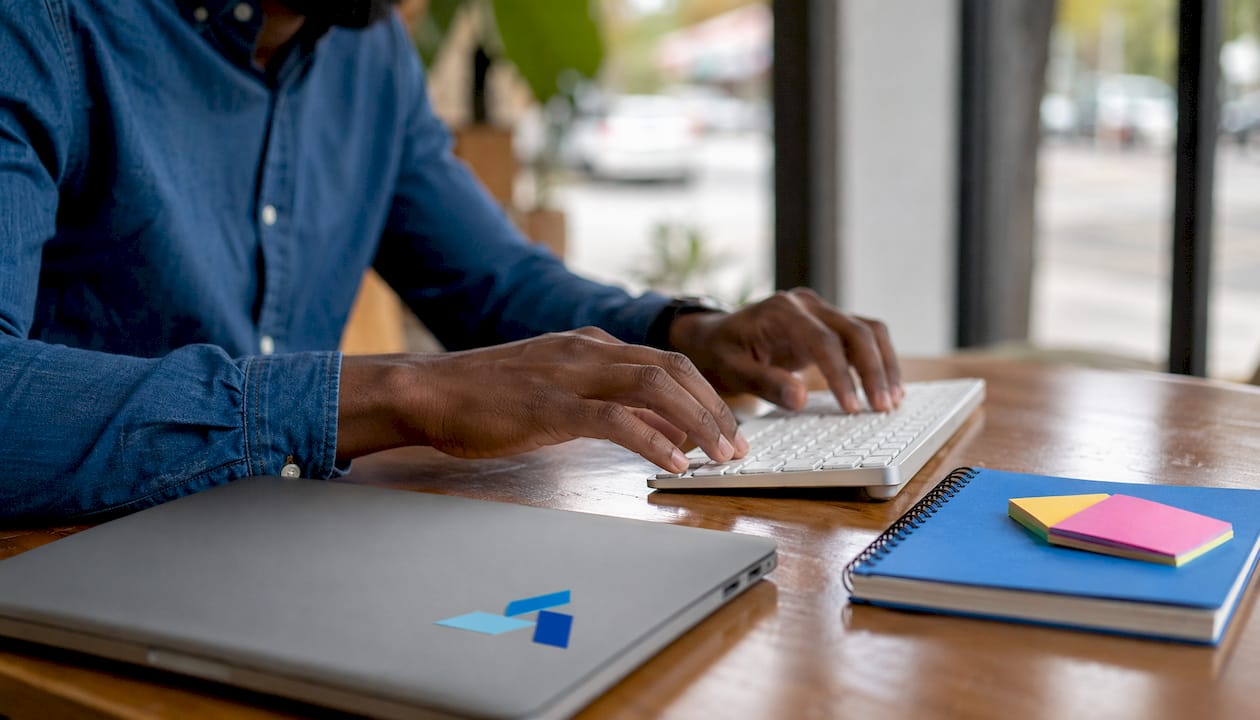 Hands typing at marketing workstation
