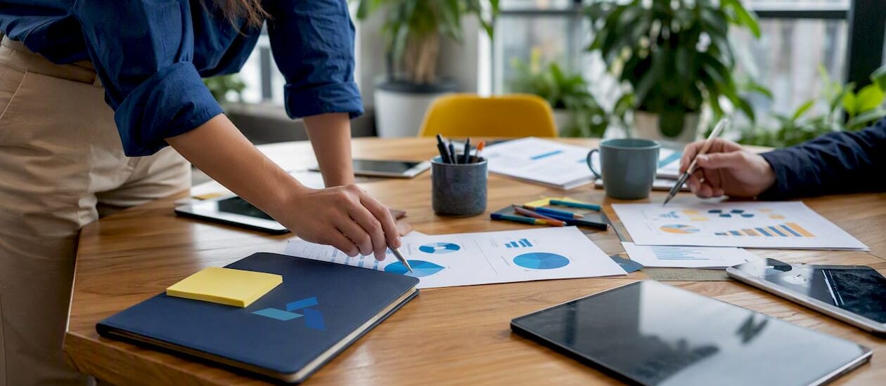 Workspace with market research documents and Blue Prysm logo