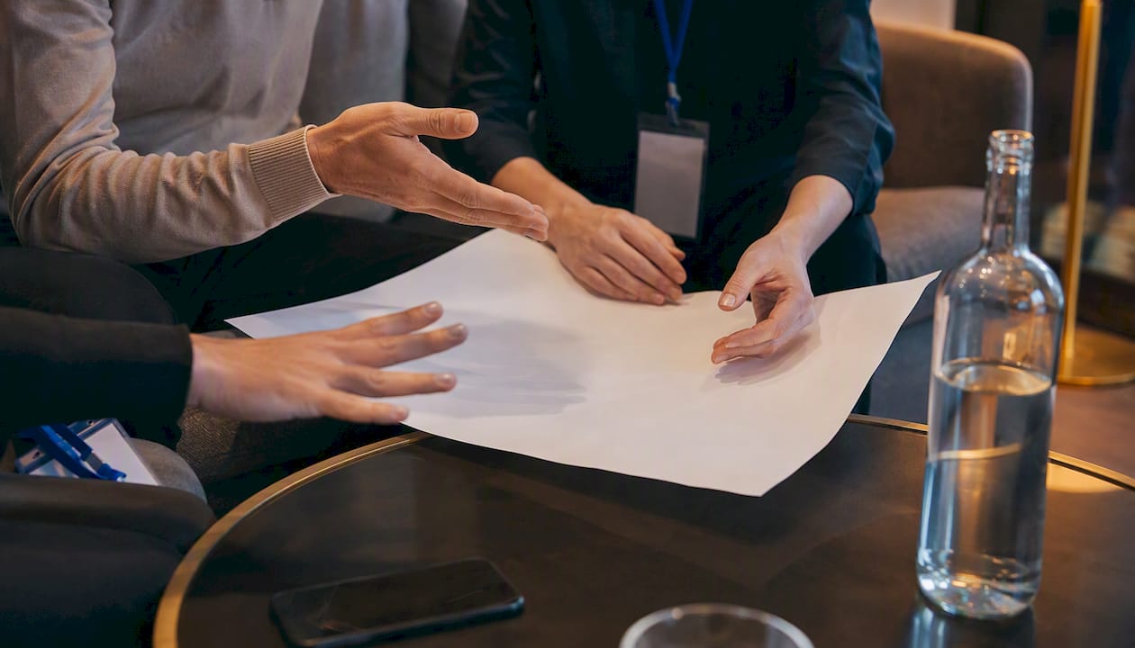 Hands pointing at strategy roadmap with Blue Prysm badge