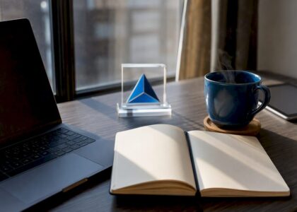 Workspace with laptop, coffee, and Blue Prysm logo