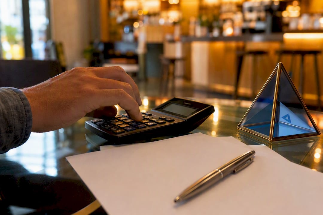 Hand using mechanical calculator on desk